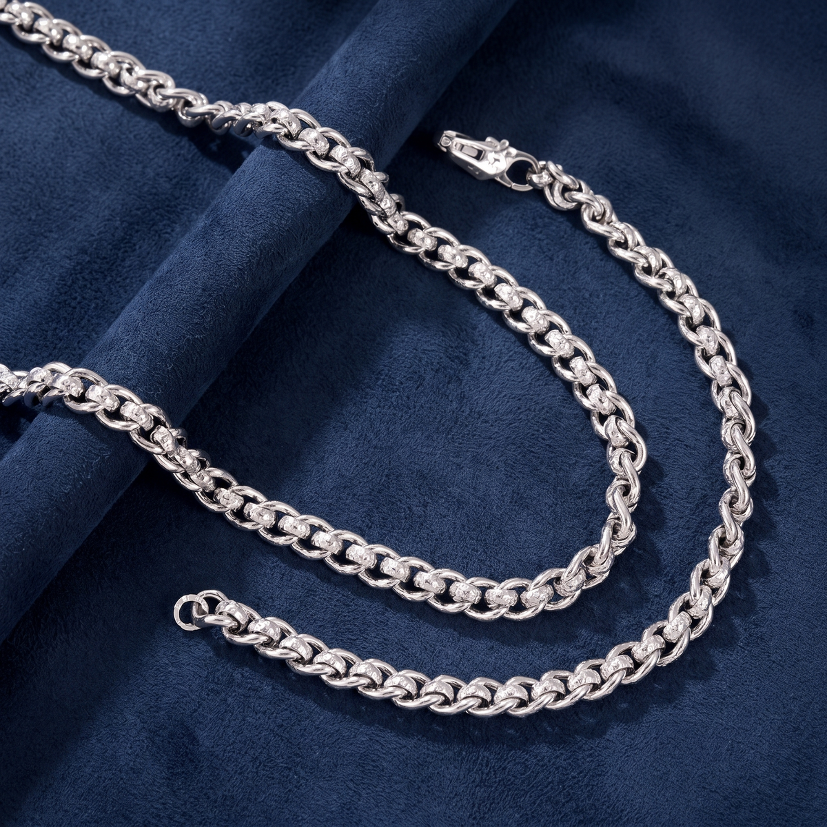 Silver woven link chain detail showing hammered finish and lobster clasp
