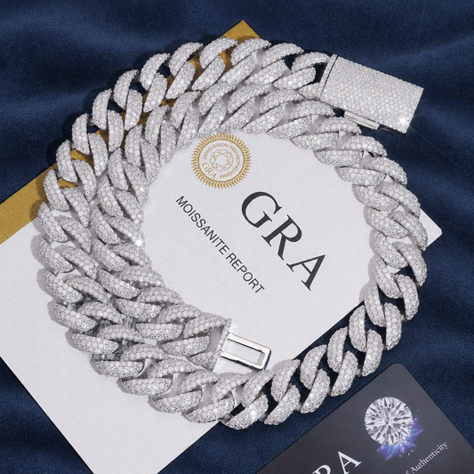 18mm Miami Cuban Chain in 925 silver coiled on navy suede beside its GRA moissanite report