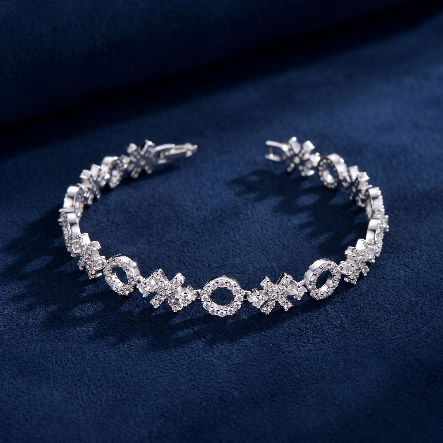 XOXO Link Bracelet open flat-lay on dark navy suede