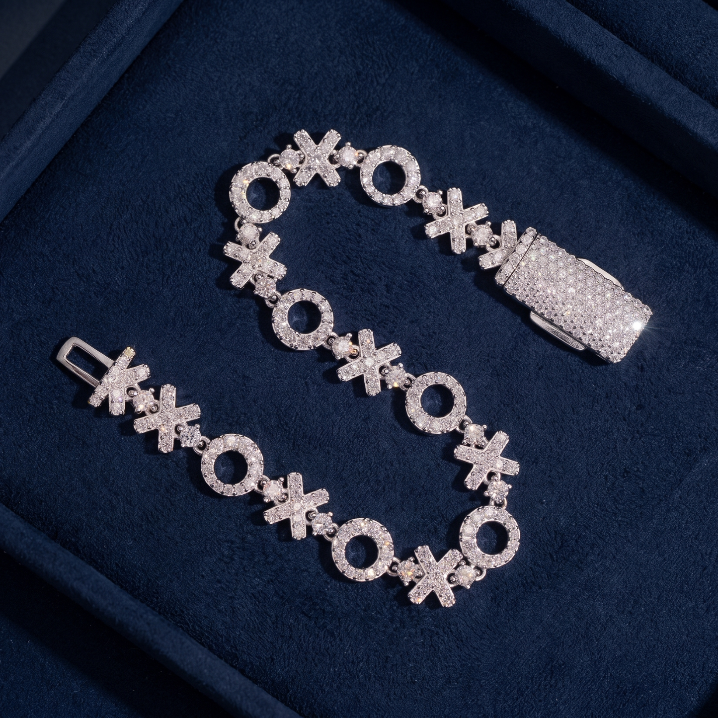 XOXO Link Bracelet with clasp open on dark navy suede