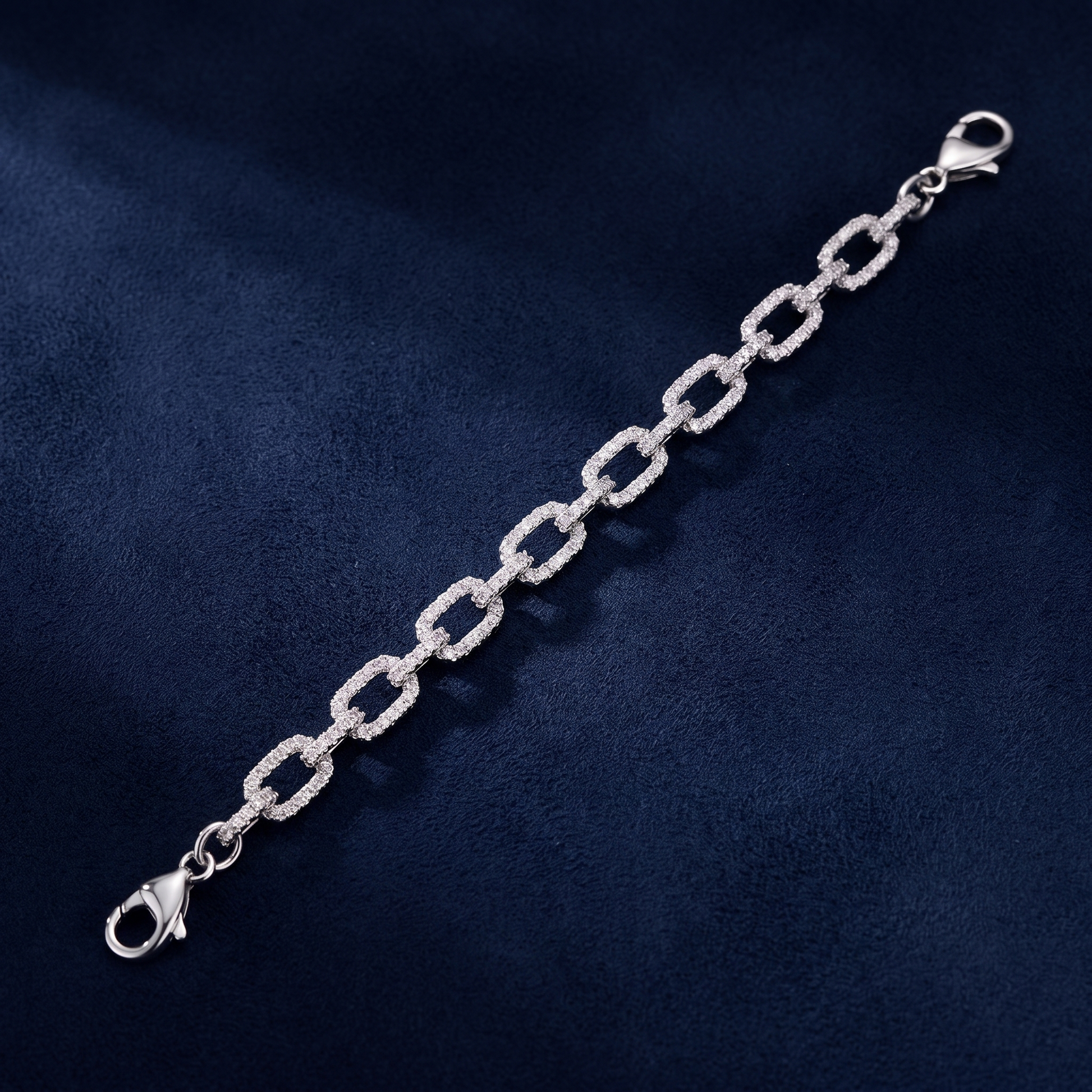 Infinity Link Bracelet diagonal view showing lobster clasp on dark navy suede
