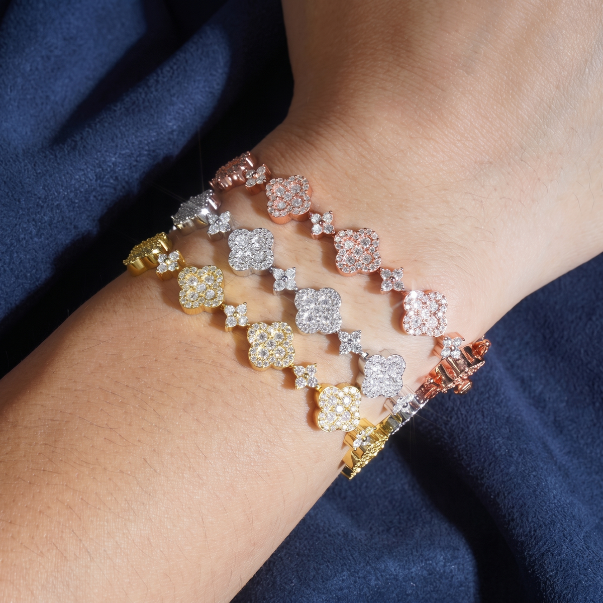 Flower cluster moissanite tennis bracelets stacked on a wrist